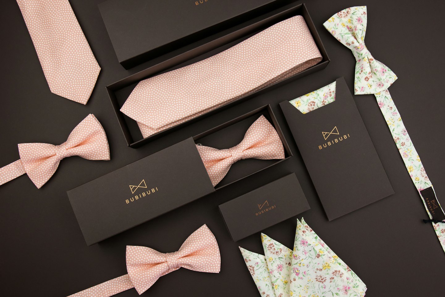 Men's ties, bow ties, and pocket squares arranged on a dark background.