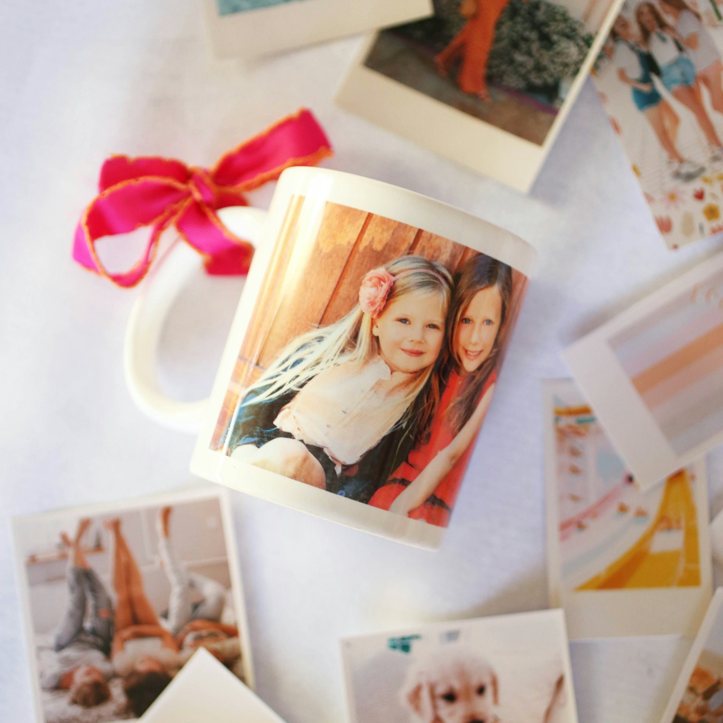 Custom photo mug decorated with ribbon surrounded by small photographs.